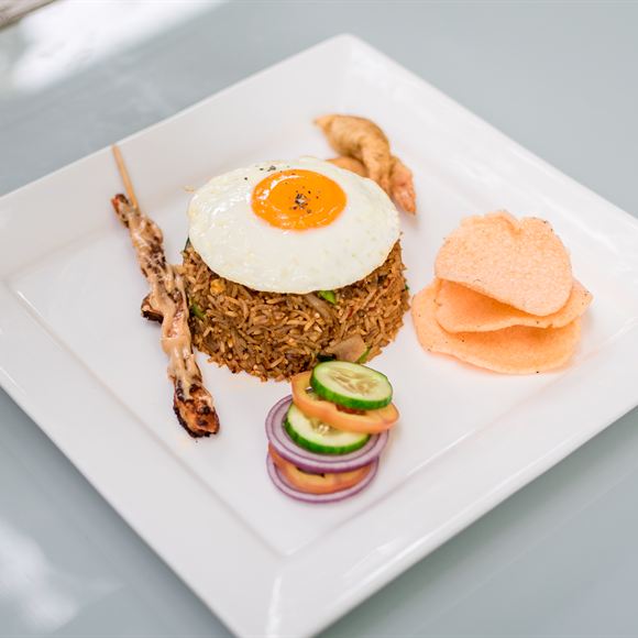 Nasi goreng at Amber Poolside, a fried egg on top and prawn crackers alongside.