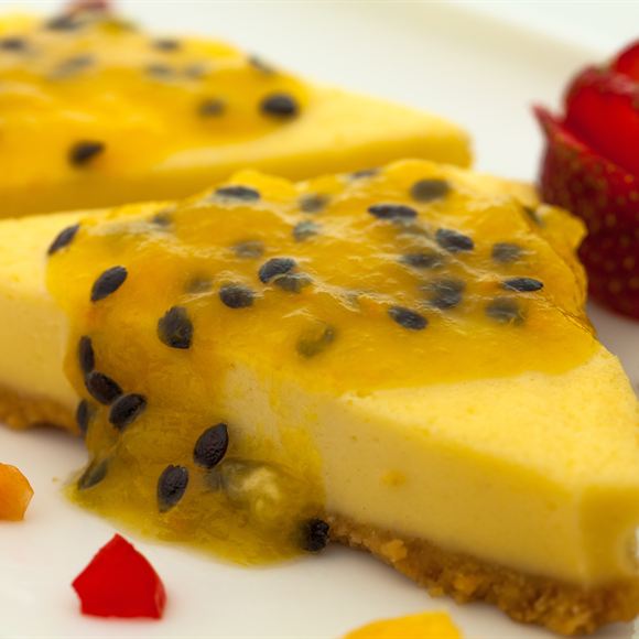 A slice of passion fruit cheesecake with the seeds across the top.
