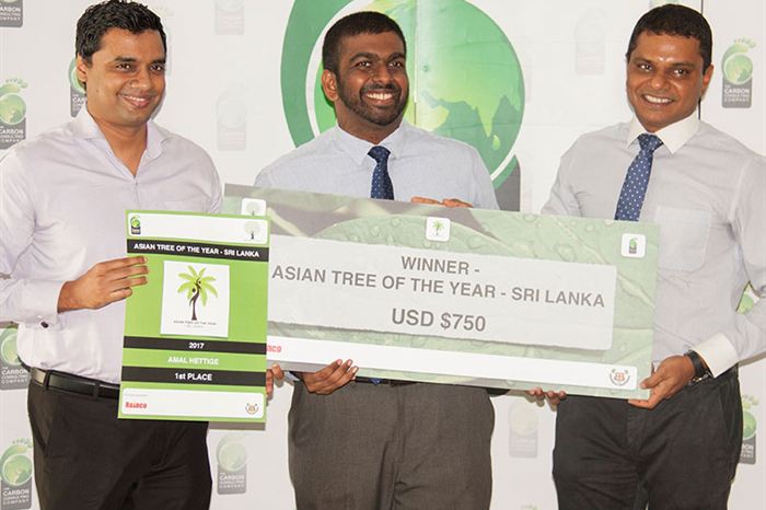 Four people holding an oversized winner’s cheque for Asian Tree of the Year Sri Lanka in front of a green backdrop.