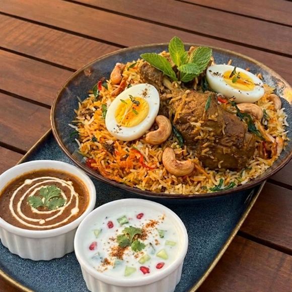 Biriyani at Cloud Caf&eacute; & Bar, served with raita and a curry sauce.
