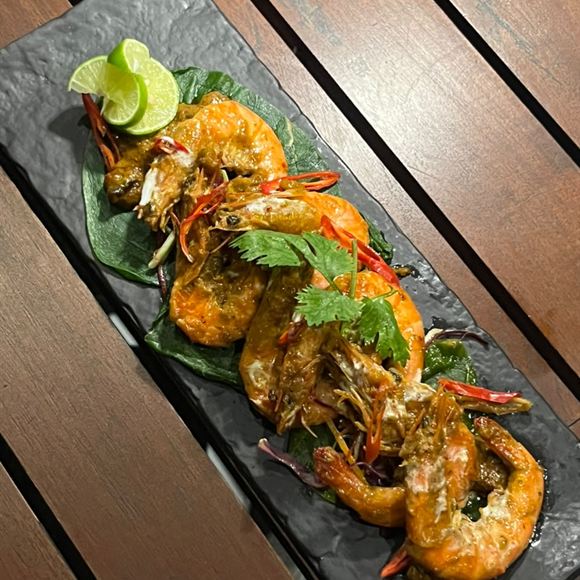 Golden coconut prawns on a slate board.