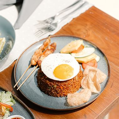 A breakfast plate at Amber Poolside: rice, a fried egg, sambol and a grilled prawn.