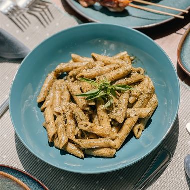 A bowl of penne with olives and herbs at Amber Poolside.