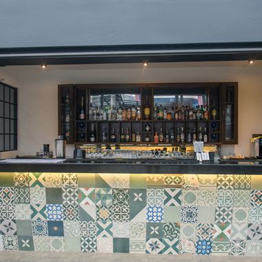 The bar at Cloud Caf&eacute; & Bar, faced in patterned Ceylon cement tiles under warm light.