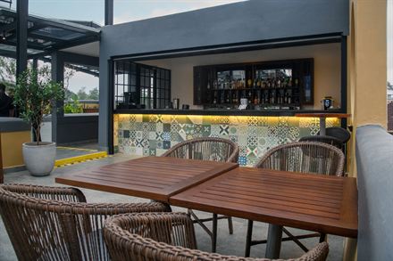 A dining table on the roof with the tiled bar behind it.