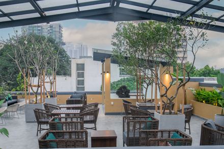 Rooftop seating at Cloud Caf&eacute; & Bar with the buildings of Colombo 3 beyond the planting.