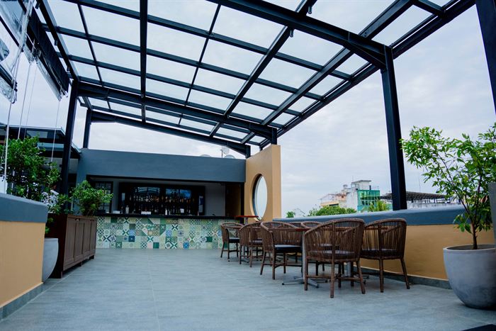 The rooftop bar at Cloud Caf&eacute; & Bar under its glass roof, with patterned tiles and city views.