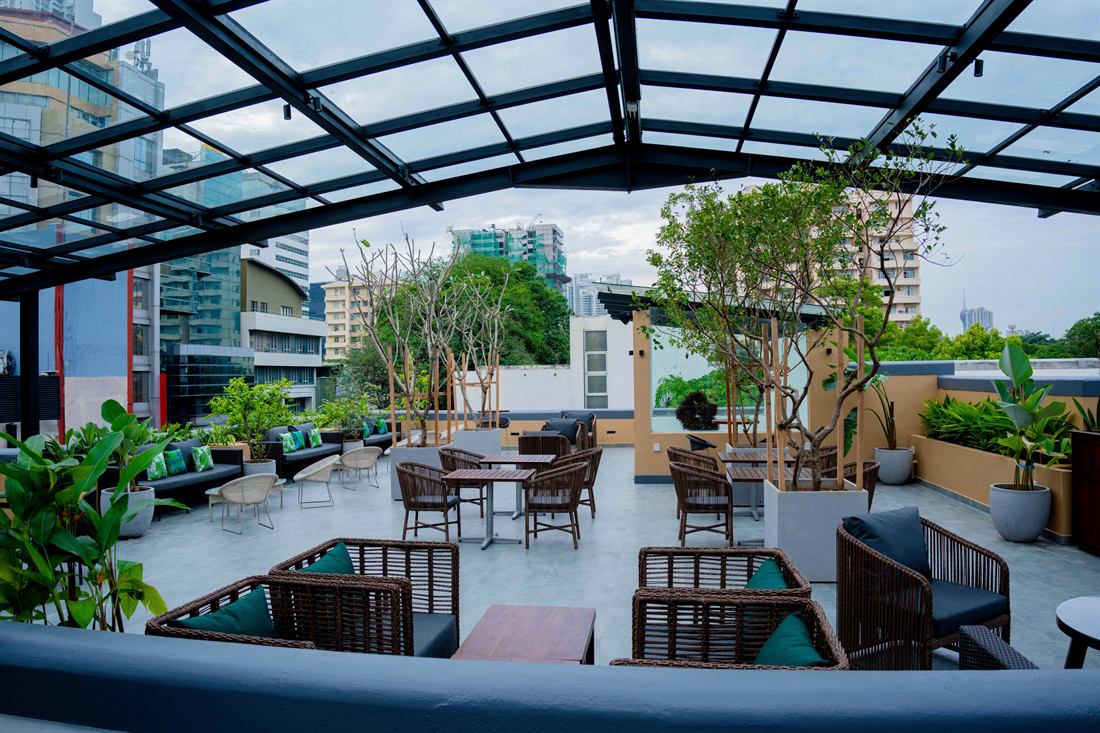 The rooftop by day, the glass roof open to the sky over the tables.