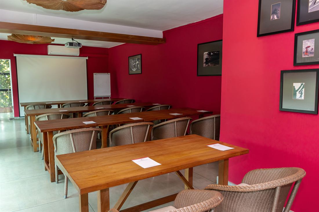 The Scarlet Room with the projector screen down and chairs around the table.