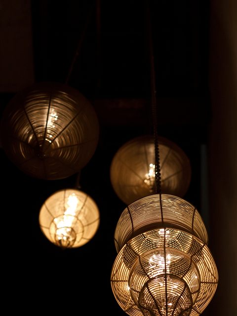 Woven rattan pendant lamps hanging in a dark stairwell at Colombo Court.