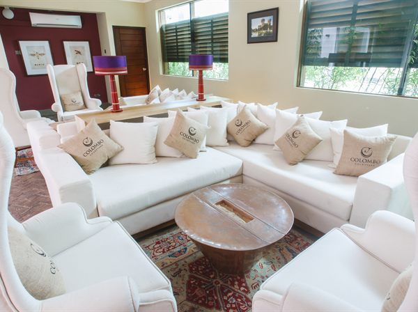 The wine lounge at Colombo Court, deep sofas and low lamps against a dark red wall.