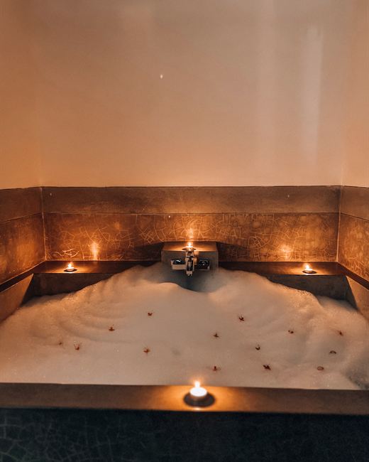 The jacuzzi at Colombo Court in low light, candles set along its stone rim.