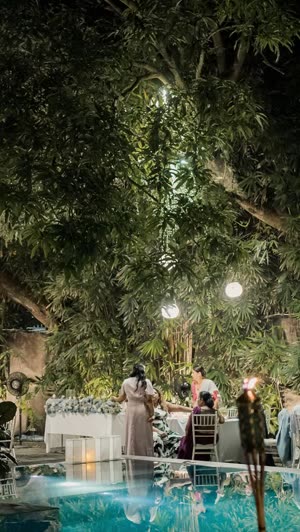 An evening reception in the garden at Colombo Court, tables in white beside the lit pool.