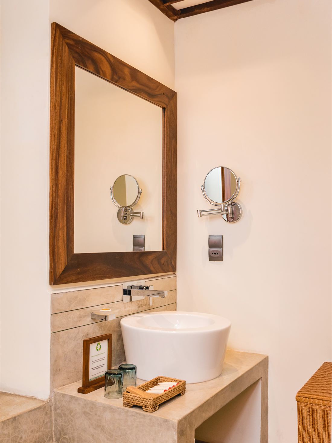 The Luxury Duplex Suite bathroom, a round basin on a stone counter under a timber mirror.