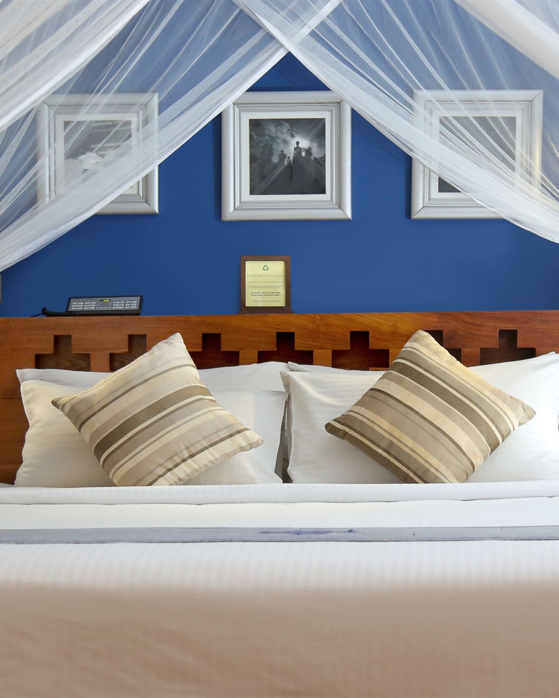 The Luxury Honeymoon Suite, four-poster bed under a mosquito net.