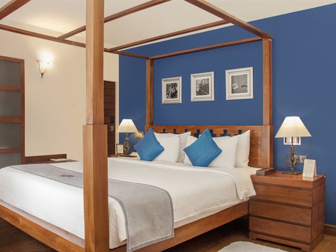 The four-poster bed, side lamps lit.