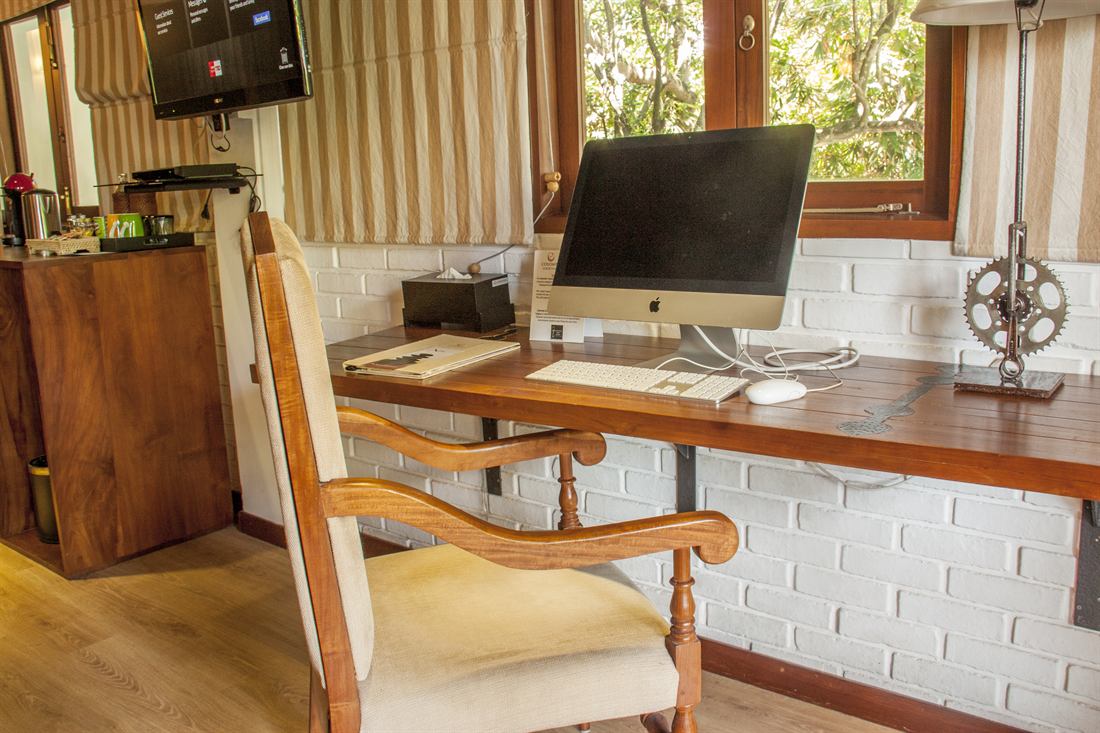 The writing desk in a Luxury Junior Suite, timber and a leather chair.