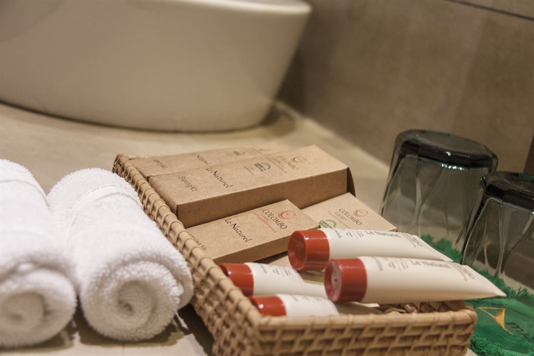 Rolled towels and toiletries on a tray in a Superior Deluxe bathroom.