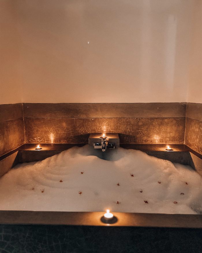 The jacuzzi at The Court Spa run for the evening, candles along the rim and petals on the water.