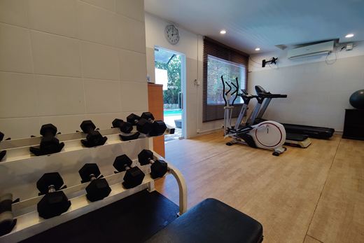 The fitness room at Colombo Court, free weights, a bench and cardio machines.