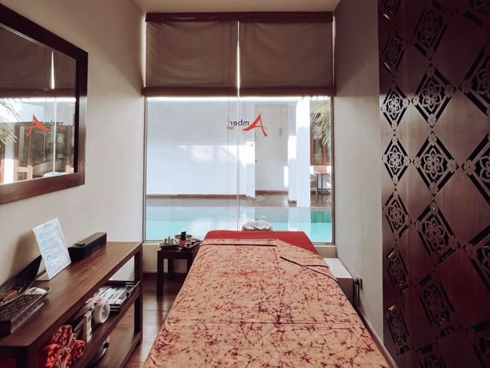A treatment room at The Court Spa, the bed made up and the pool visible through the window.