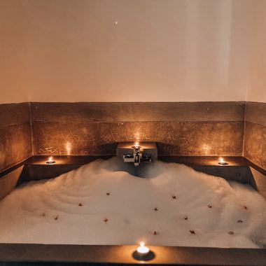 The jacuzzi at The Court Spa lit by candles, petals on the water.